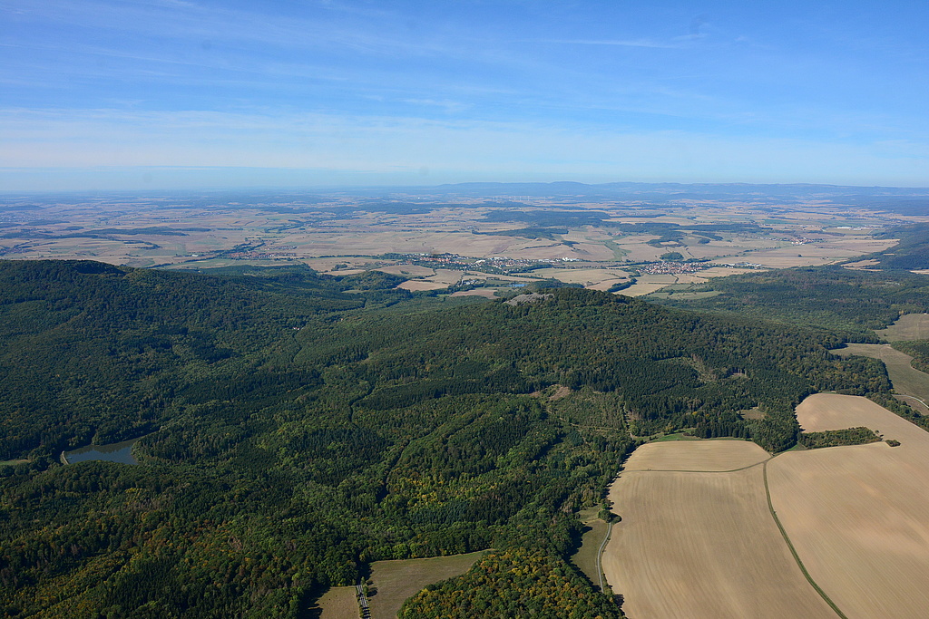NSG 349, Blick von Ostnordost auf den Kleinen Gleichberg im NSG "Gleichberge". Links vorn: Talsperre Roth II ("An der oberen Milz"), dahinter: Nordseite des Großen Gleichberges mit dem ehemaligen Römhilder (Basalt-)Bruch, Bildmitte hinten: Stadt Römhild, rechts daneben: Haina (Gemeinde Römhild). (Foto: Detlef Stremke/Archiv TLUBN, 22.09.2019)