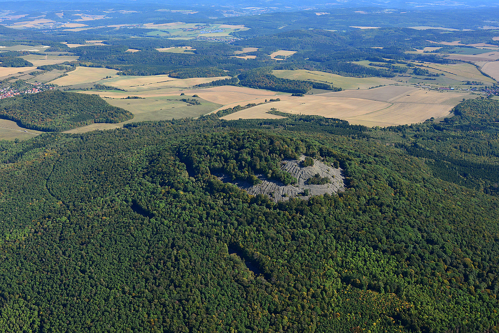 NSG 349, Blick von Südwesten auf den Kleinen Gleichberg mit der Steinsburg mit Basaltblockmeer im NSG "Gleichberge". Am Bildrand hinten links: Dingsleben, hinten rechts: Zeilfeld (Gemeinde Römhild). (Foto: Detlef Stremke/Archiv TLUBN, 22.09.2019)