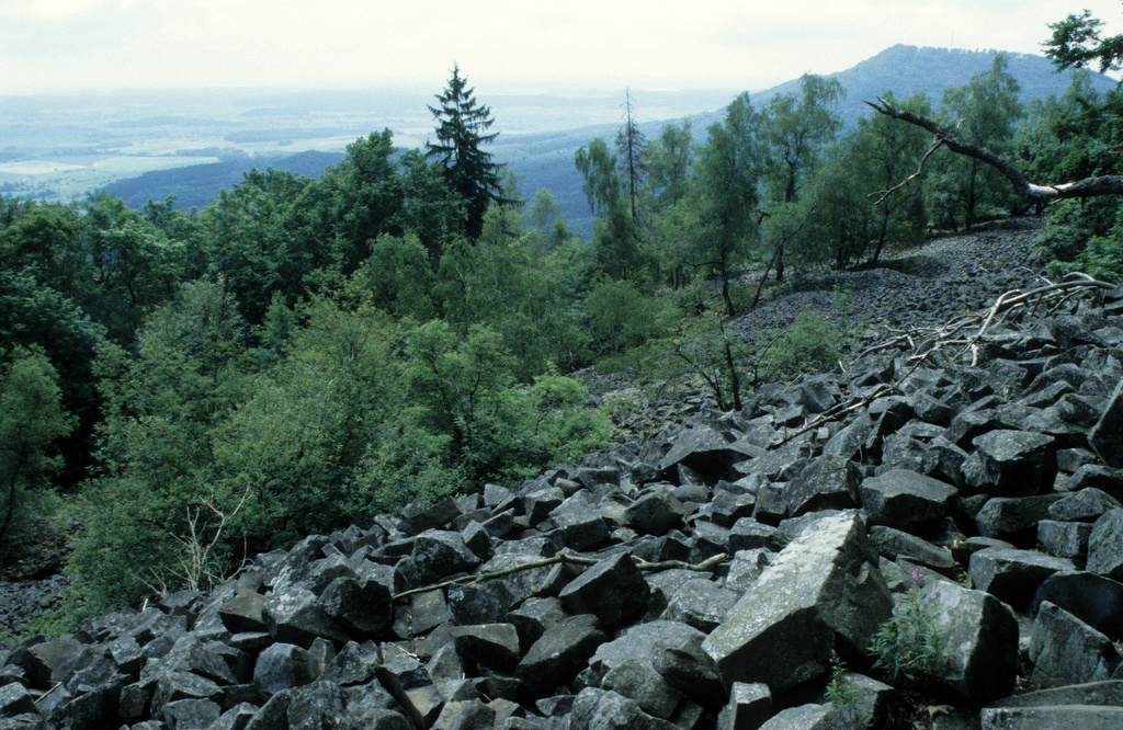 NSG 349, Basaltblockmeer auf der Südostseite des Kleinen Gleichberges unterhalb des Gipfels. Hinten rechts: der Große Gleichberg. (Foto: Holm Wenzel, 09.07.1997)