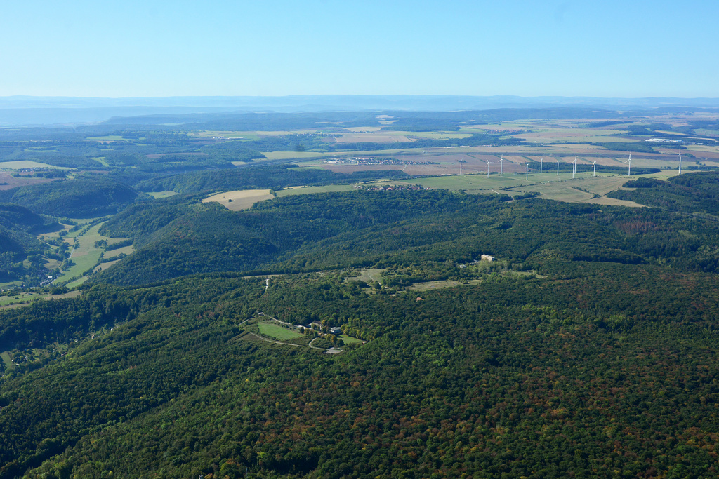 NSG 452, Blick von Nordosten auf den mittleren und südlichen Teil des NSG und FFH-Gebietes "Jenaer Forst" (Stadt Jena, Saale-Holzland-Kreis). In der Bildmitte außerhalb des FFH-Gebietes und NSG: Otto-Schott-Platz (vorn) und ehemaliges, jetzt renaturiertes Kasernengelände der Sowjetarmee, links am Bildrand: Tal des Ammerbaches zwischen Jena-Ammerbach und Nennsdorf. (Foto: Detlef Stremke/Archiv TLUBN, 21.09.2019).